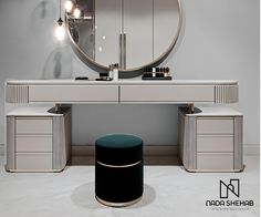 a white vanity with a round mirror and stool