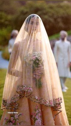 a woman in a wedding dress with flowers on her veil