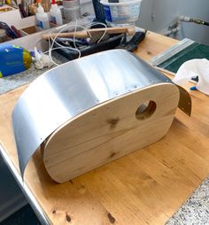 a roll of tin foil sitting on top of a wooden table next to some tools