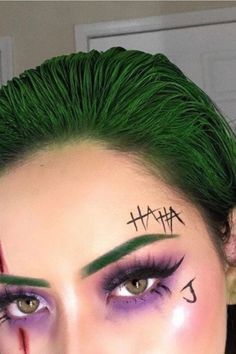 a woman with green hair and makeup is looking at the camera while she has her eyes painted