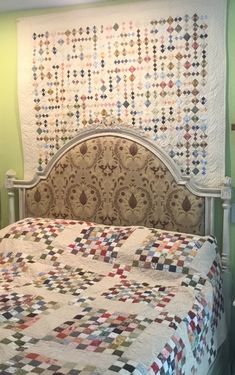 a bed with a quilt on the headboard and foot board in front of it