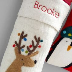 two christmas stockings decorated with reindeer and penguin