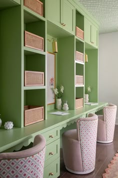 a row of green and pink chairs in front of shelves with baskets on top of them