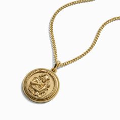 a gold necklace with an image of a woman on it