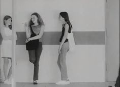 three young women standing in front of a wall