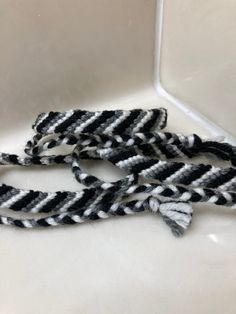 two black and white braided ties sitting on top of a counter