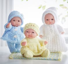 three knitted baby dolls sitting next to each other