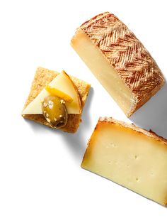 three different types of cheese are arranged on a white surface