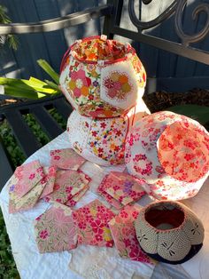 several pieces of fabric sitting on top of a table next to a basket and bowl