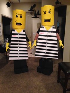 two legos dressed in jail clothes standing next to each other