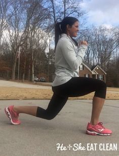 a woman is running in the street with trees behind her