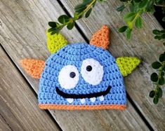 a crocheted blue hat with orange horns and eyes