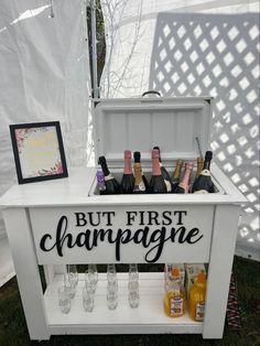 an ice chest with champagne bottles in it and a sign that says, but first champagne