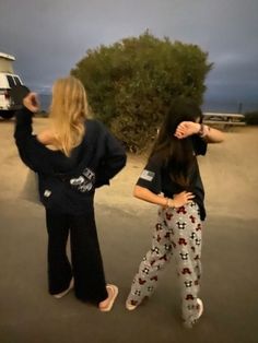 two women standing in the middle of a parking lot