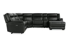 a black leather sectional sofa with recliners on the back and armrests