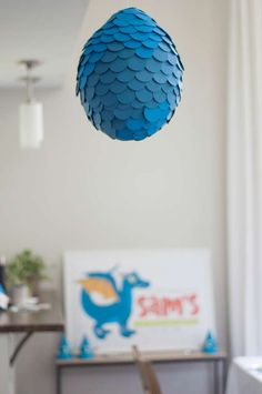 a blue ball hanging from the ceiling in a room with white walls and flooring