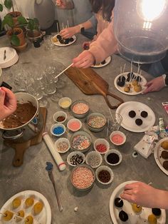 a group of people sitting around a table preparing food