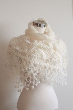 a white knitted shawl on top of a mannequin's head