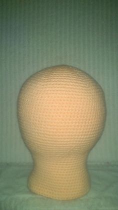 a white knitted head sitting on top of a bed