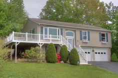 a two story house with white balconies on the front and second story above it