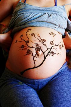 a pregnant woman with tattoos on her stomach