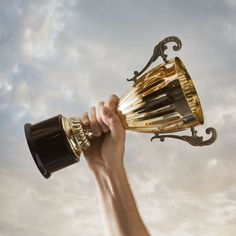 a hand holding up a trophy in the air