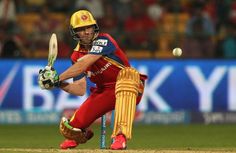 a man in red and yellow uniform playing a game of cricket