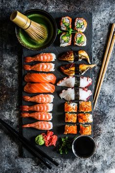 sushi and chopsticks laid out on a slate board