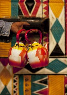 two red and yellow tea kettles hanging from the ceiling