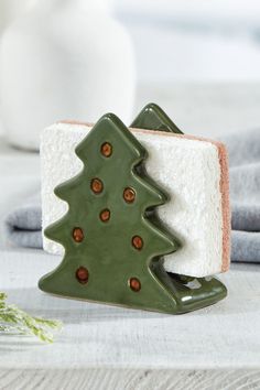 a green ceramic christmas tree sitting on top of a piece of white bread next to a bottle of milk