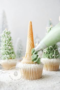 someone is decorating cupcakes with green frosting and an ice cream cone