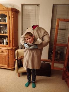 a little boy standing in front of a man wearing a trench coat