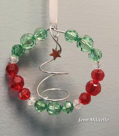 a christmas tree ornament made from glass beads and silver wire with a star on top