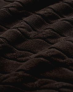 a close up view of the texture of a black blanket that has been folded over