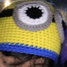 a close up of a person wearing a knitted hat with an evil looking eye