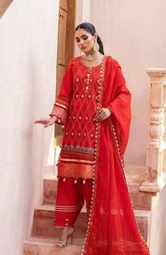 a woman in red is standing on steps wearing a red outfit with gold details and beads