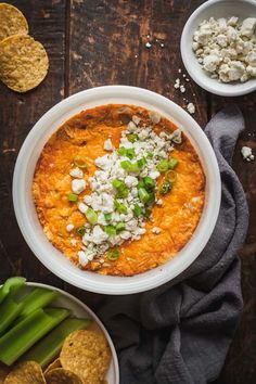 an overhead view of a bowl of vegetarian buffalo dip with tortilla chips and celery