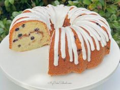 a bundt cake with white icing and blueberries