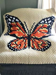 a crocheted butterfly pillow sitting on top of a chair