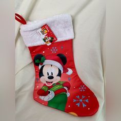 a mickey mouse christmas stocking hanging on a bed