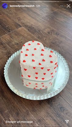 a heart shaped cake sitting on top of a white plate with red hearts on it