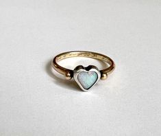 This darling one of a kind ring features a beautiful Australian opal heart which I set in a chunky handmade sterling silver bezel. It sits perched atop a heavy fun round 14k yellow antique reclaimed wedding band, which has an engraving of 9-15-56 along with initials in cursive. I melted two little gold pebbles from scrap and flanked the stone with them. I oxidized the silver bezel to a darker black finish, to contrast with the stone and the yellow gold. One Of A Kind Heart Jewelry For Anniversary, One-of-a-kind Opal Jewelry For Anniversary, Handmade 14k Gold Opal Ring For Anniversary, Handmade Dainty Opal Ring For Anniversary, Heirloom Opal Ring With Polished Finish Gift, Heart Shaped Opal Jewelry For Anniversary, One Of A Kind Opal Ring For Anniversary, 14k Gold Wedding Band, Bezel Ring