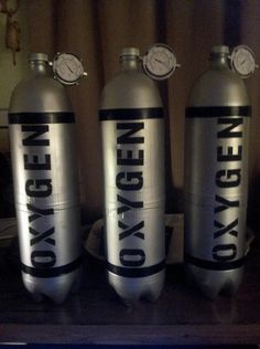 three oxygen cylinders with the words oxygen oxygen written on them are sitting on a table