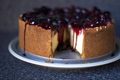 a cheesecake with blueberries and sauce on top