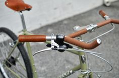 the handlebars and bars on this bike are made out of metal, with brown leather