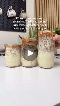 three jars filled with food sitting on top of a white counter next to a plant