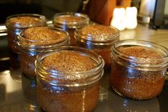 several jars filled with brown sugar sitting on top of a metal counter next to a blender