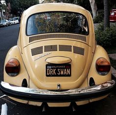 an old yellow car is parked on the street