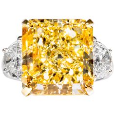 This fancy yellow radiant diamond is offered by Shreve, Crump & Low. The radiant cut diamond is custom set in a handcrafted Shreve, Crump & Low platinum and 18 karat yellow gold 3 stone ring consisting of 1 radiant cut yellow diamond weighing 14.63 carats with color and clarity of Fancy Yellow VS1 accompanied by GIA report No. 11229045, accented by two half moon shaped diamonds with a total weight of approximately 1.54 carats, and a respective color and clarity of D-E VS1-VS2 quality. The setting is a ring size 6.5, and is stamped with our maker's hallmark "SC&L" "PLAT" "18k" on inside of ring shank. Shreve, Crump & Low is one of America's oldest and most prestigious jewelry and fine gift establishments founded in 1796. Shreve, Crump & Low has storefronts in Boston, MA and Greenwich, CT. F Fantasy Rings, David Morris, Radiant Diamond Rings, Radiant Ring, Blue Diamond Engagement Ring, Bling Ideas, Canary Diamond, Ring Bands, Genie Bottle