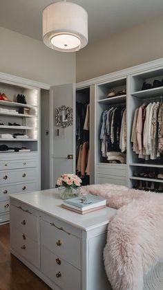 an organized closet with white drawers, shelves and pink fur rugs on the floor